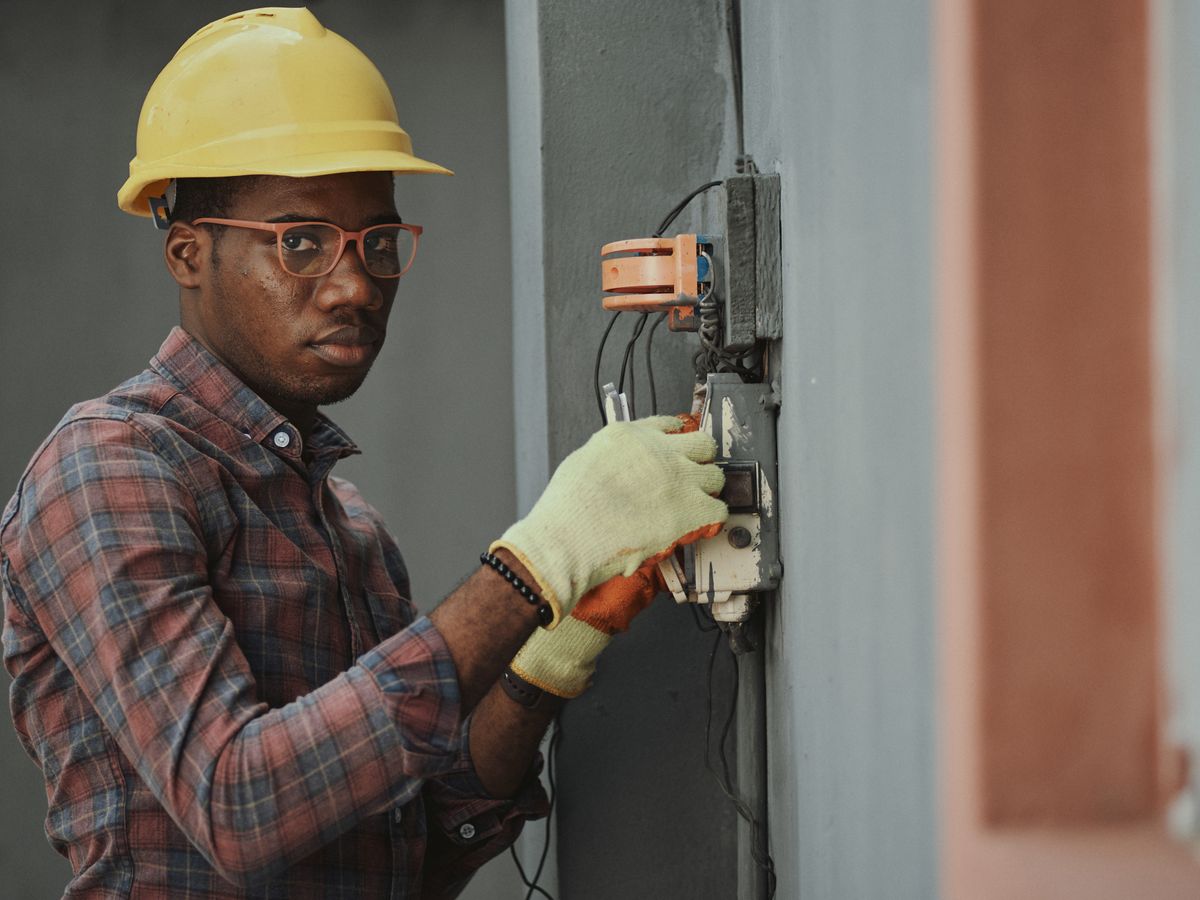 A qualified electrician working on a consumer unit